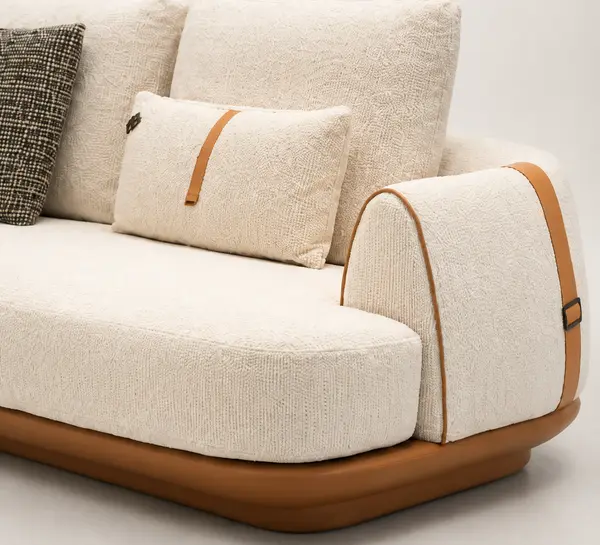 Close-up of tan leather trim detail on cream boucle sofa