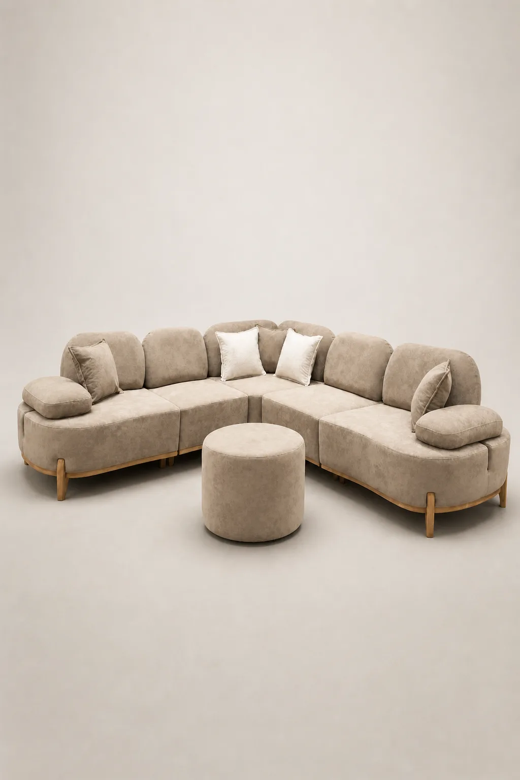 Beige curved sectional sofa with rounded silhouette and round ottoman.