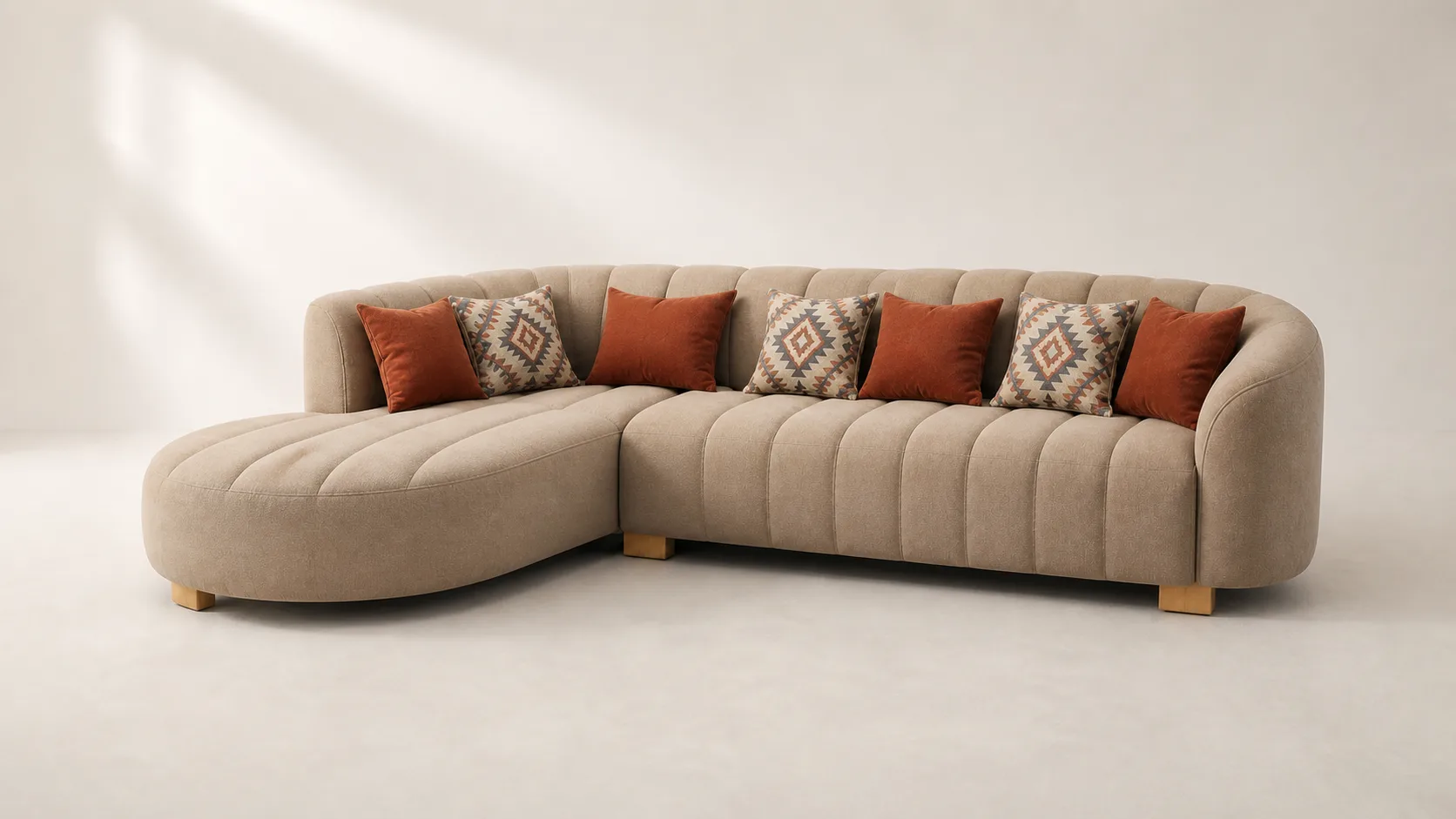 Taupe channel-tufted curved L-shaped sofa with rust and kilim-pattern cushions.