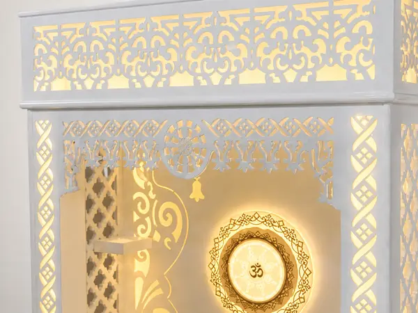 Close-up of the scrollwork pediment and backlit Om wheel medallion