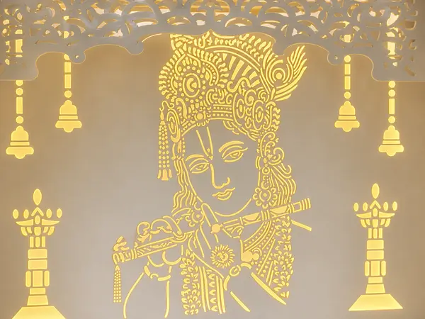 Close-up of the backlit Radha-Krishna jaali panel and carved temple bells